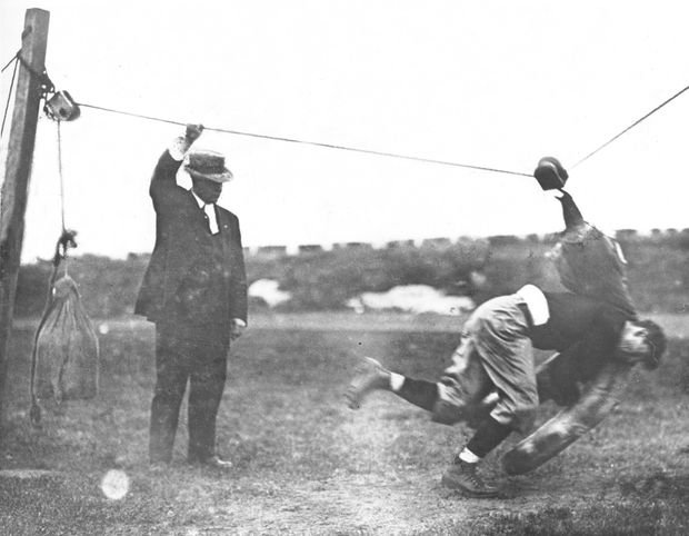 Coach Glenn "Pop" Warner (left) watches Jim Thorpe hit a tackling dummy at Carlisle